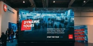 Große LED-Wand auf der Hannover Messe mit dem Startbildschirm der Dynamic Tour zum Thema Künstliche Intelligenz